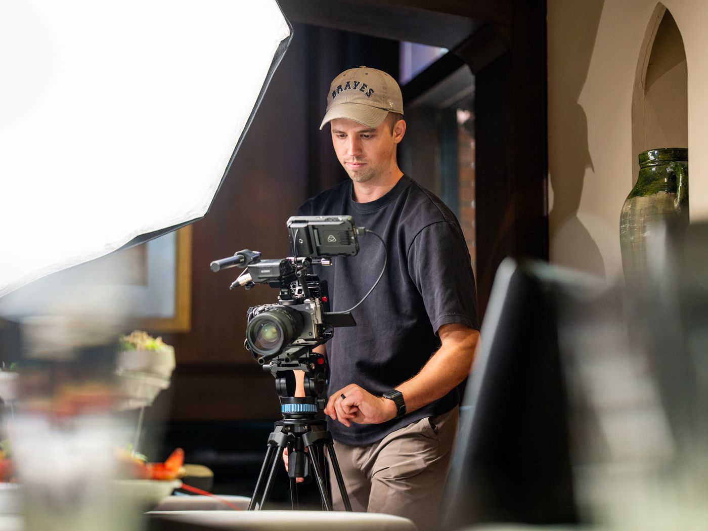 Tim Knoedler setting up a camera on a tripod beside a large softbox on a restaurant shoot