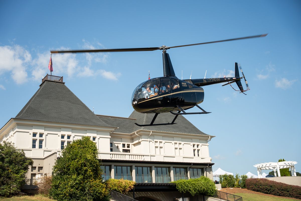 A helicopter lifting off beside the château